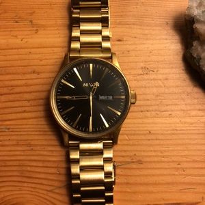 Gold plated stainless steel black face Nixon watch